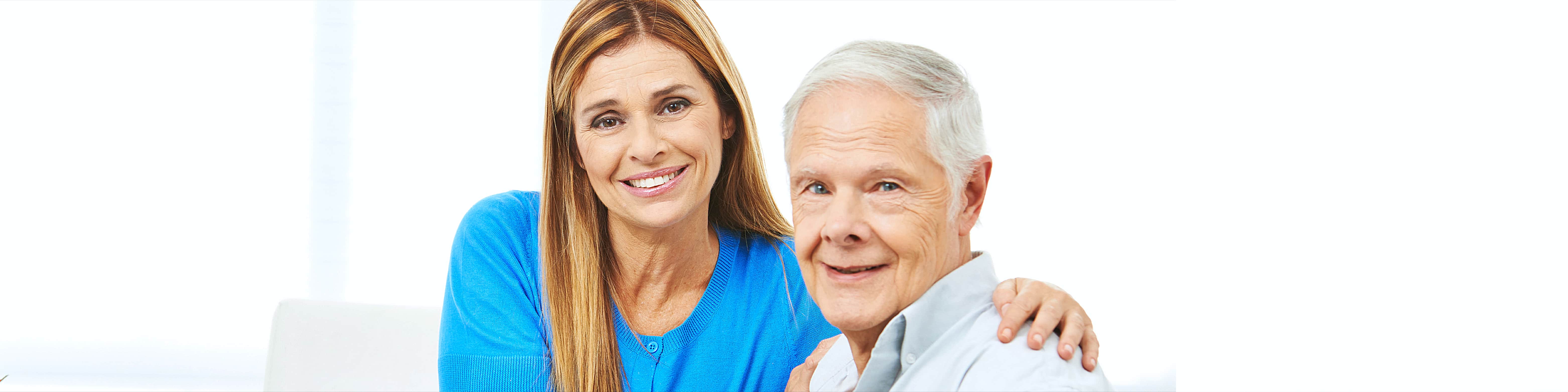 elderly man with female caregiver smiling